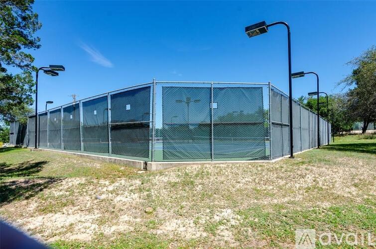 A chain link fence encloses a grassy area.