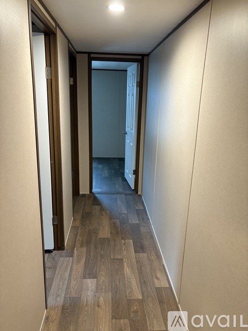 A hallway with wooden floors and white walls.