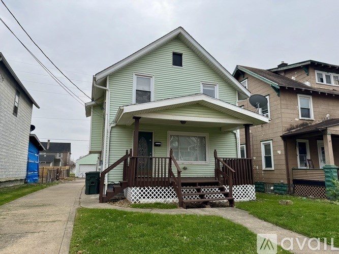 A house with a green front yard and a white picket fence.