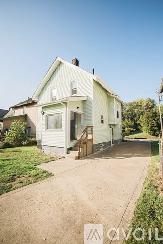 A house with a greenish exterior and a brown door.