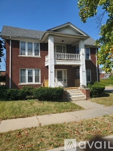 A red brick house with a white porch.