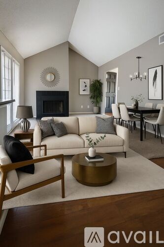 A living room with a white couch and a fireplace.