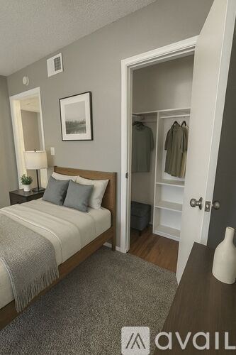A bedroom with a bed, nightstand, lamp, and a closet.