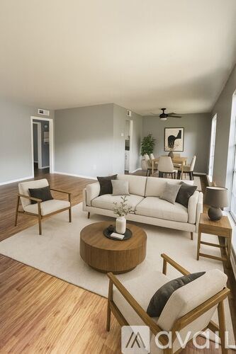 A living room with a white couch and wooden furniture.