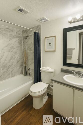 A bathroom with a toilet, sink, and bathtub.