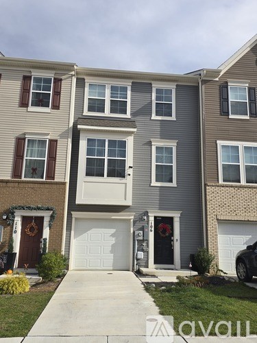 A row of houses with garages and front doors.