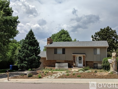 A house with a white door and a brick chimney is for sale.