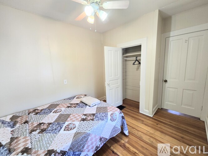 A bedroom with a bed and a ceiling fan.