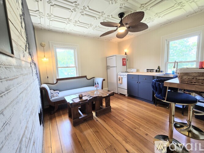 A living room with a couch, a coffee table, and a ceiling fan.