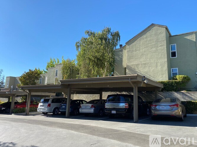 A parking lot with cars and a building in the background.