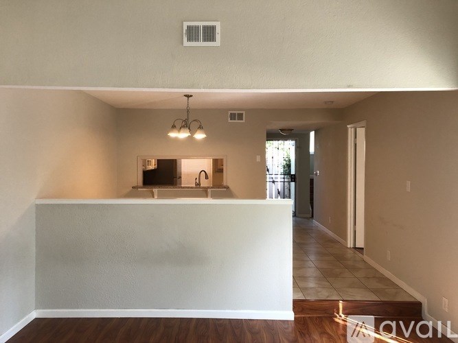 A room with a white wall and a wooden floor.