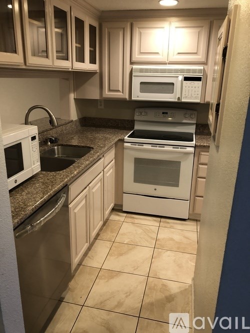 A kitchen with a sink, microwave, and oven.