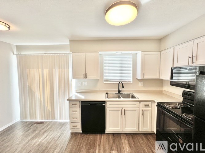 A kitchen with white cabinets and a black stove top oven.