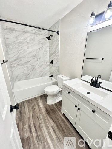 A white bathroom with a marble tile shower.