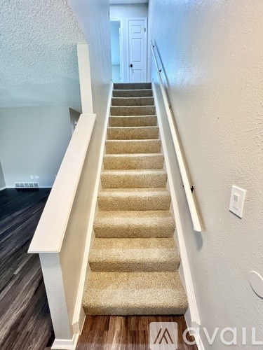 A staircase with beige carpeted steps and white railings.