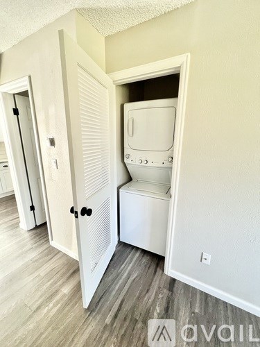 A white fridge is in a small alcove in a room.