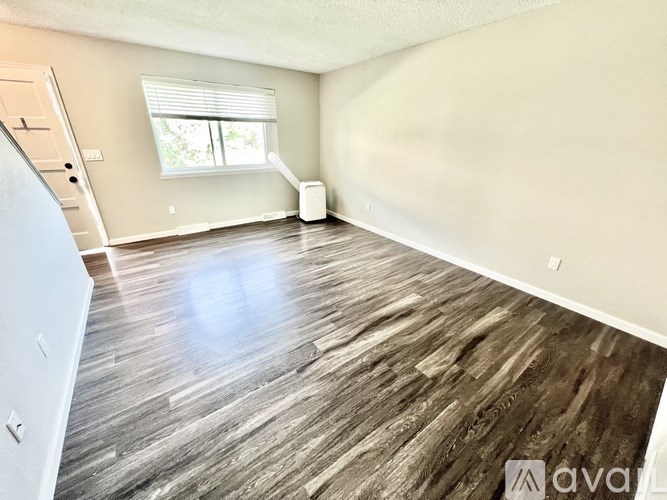 A room with wooden flooring and a window.