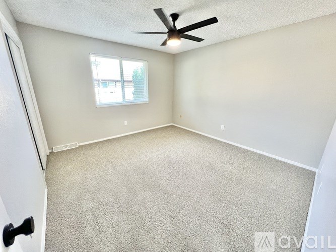 A room with a ceiling fan and a window.