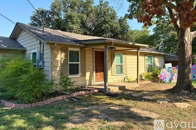 A house with a yellow siding and a brown door is for sale.