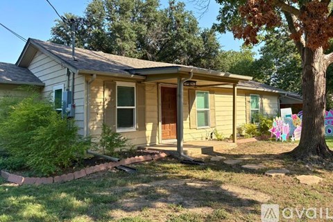 A house with a yellow siding and a brown door is for sale.