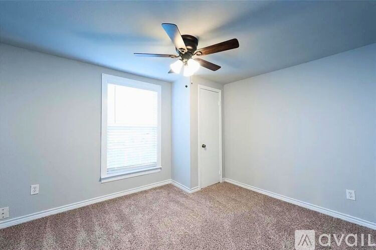 A room with a ceiling fan and a window.