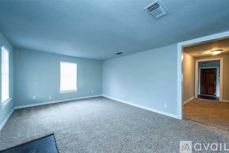 A room with a carpeted floor and a doorway leading to another room.