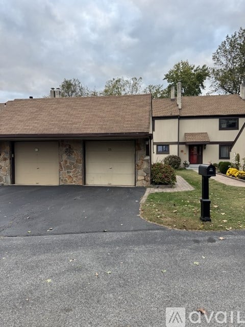 A house with a driveway and a mailbox in front.
