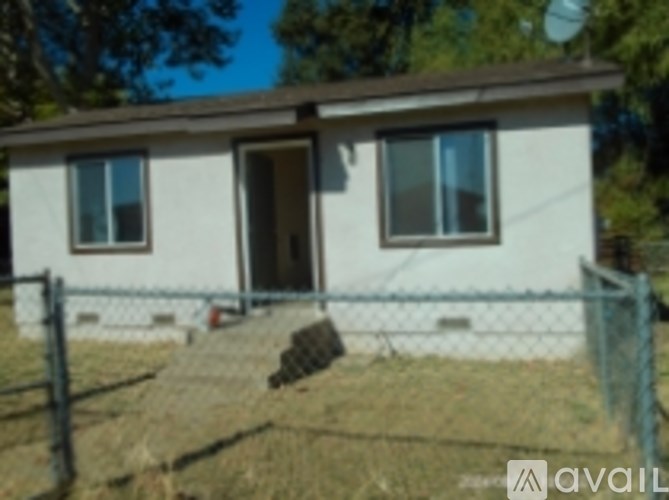A white house with a brown roof and a brown door.