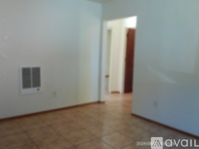 A room with a tiled floor and a doorway leading to another room.