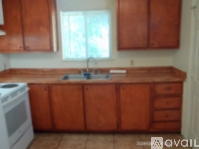 A kitchen with wooden cabinets and a white stove.