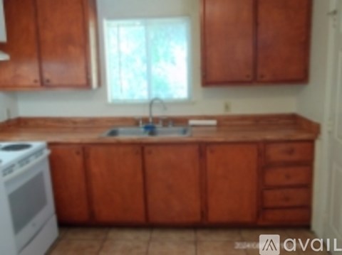 A kitchen with wooden cabinets and a white stove.