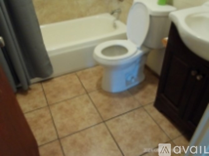 A toilet with the seat up in a bathroom.