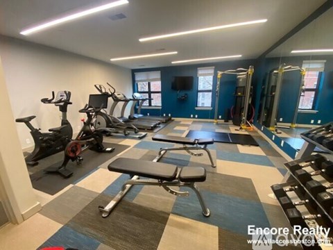 A gym with a variety of equipment including treadmills, exercise bikes, and weight machines.