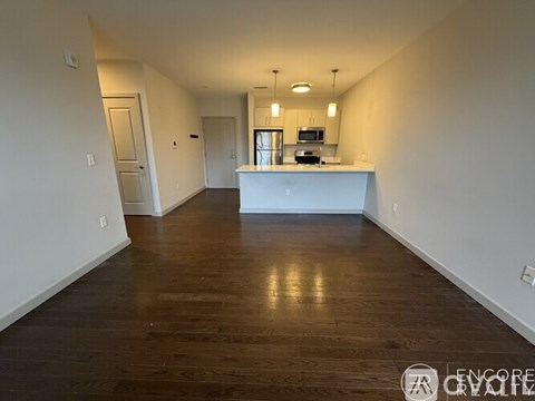 A long hallway with a kitchen area at the end.