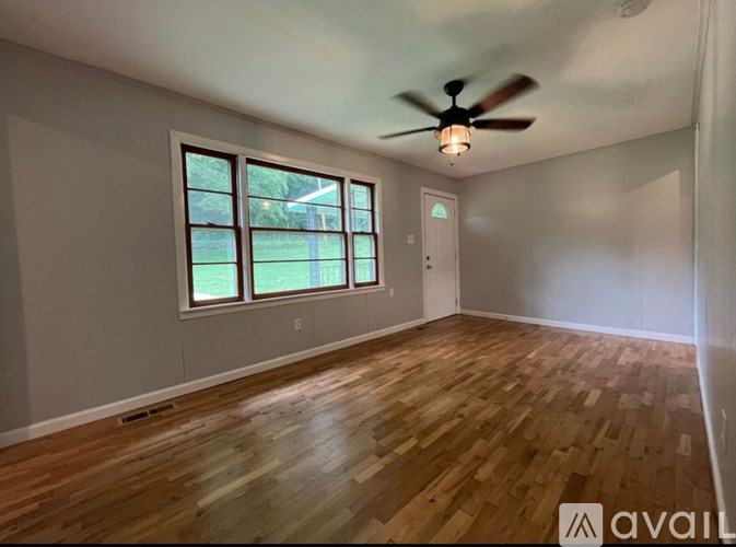 A room with wooden flooring and a ceiling fan.