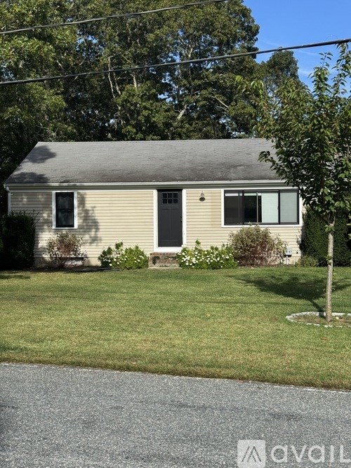 A small house with a grey roof and a brown door.