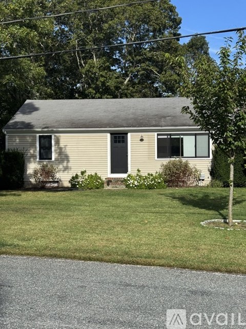 A small house with a grey roof and a brown door.