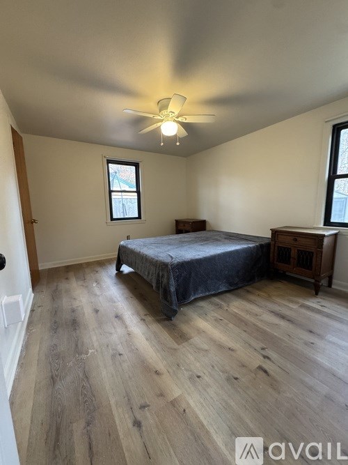 A bedroom with a bed, dresser, and window.
