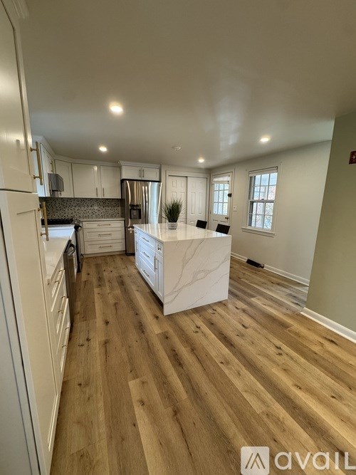 A kitchen with wooden floors and white appliances.