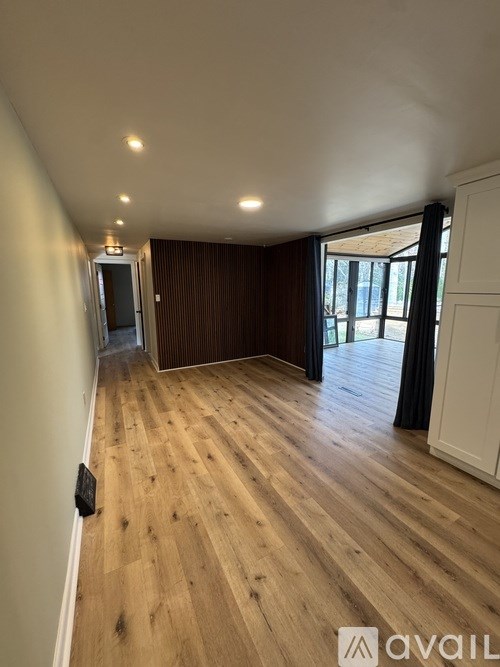 A room with wooden flooring and a white wall.