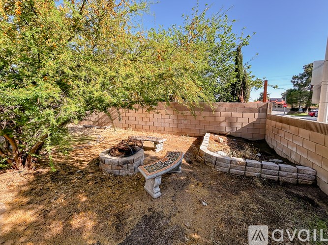 A backyard with a fire pit and a wall.