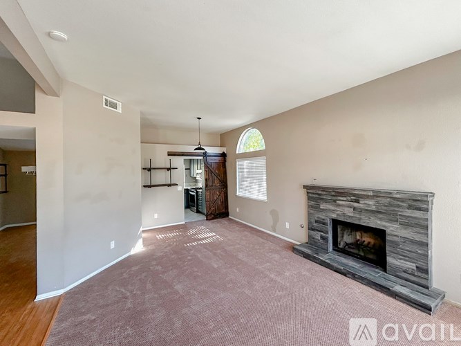 A living room with a fireplace and a large window.