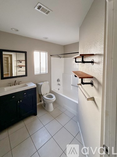 A bathroom with a toilet, sink, and bathtub.