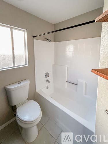 A white toilet sits next to a bathtub in a bathroom.