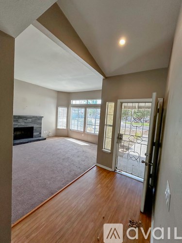 A room with a fireplace and a carpeted floor.