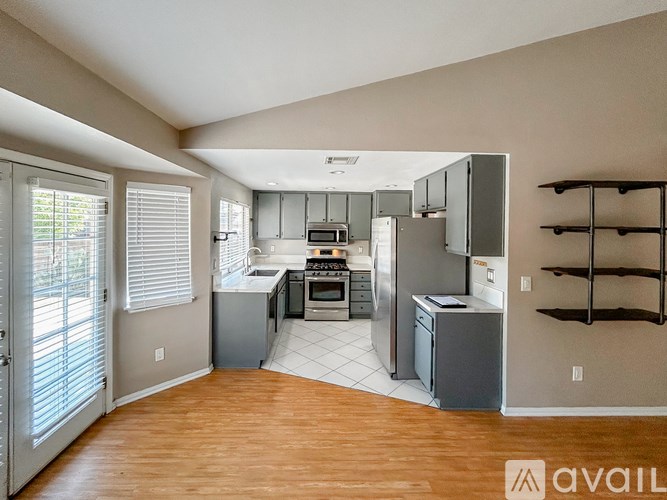 A kitchen with wooden floors and a refrigerator.