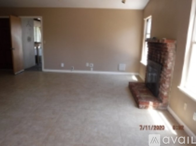A room with beige walls and carpeting is available for rent or sale.
