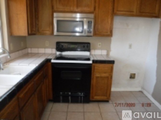 A kitchen with wooden cabinets and a black stove top oven.