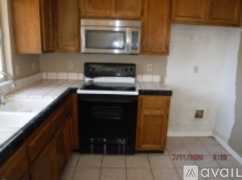 A kitchen with wooden cabinets and a black stove top oven.