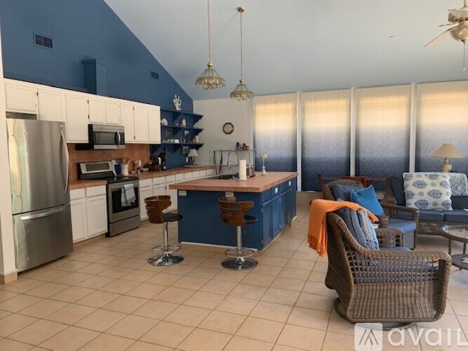 A kitchen with blue walls and white cabinets.
